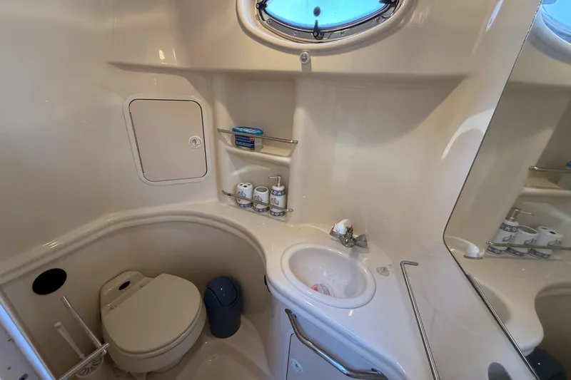 Slide: The Image of 2003 Sea Ray 300 Sundancer bathroom with sink, toilet, and storage shelves. - 41