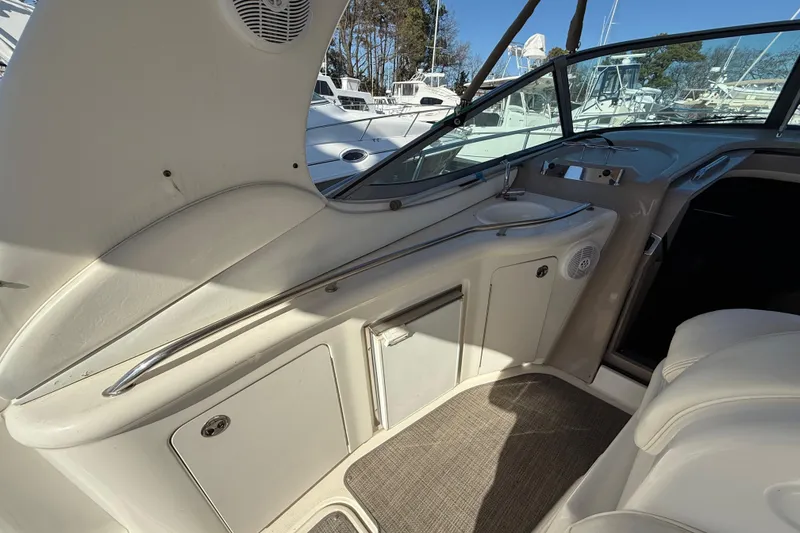 Slide: The Image of 2003 Sea Ray 300 Sundancer interior with sink and seating area, docked at marina. - 9