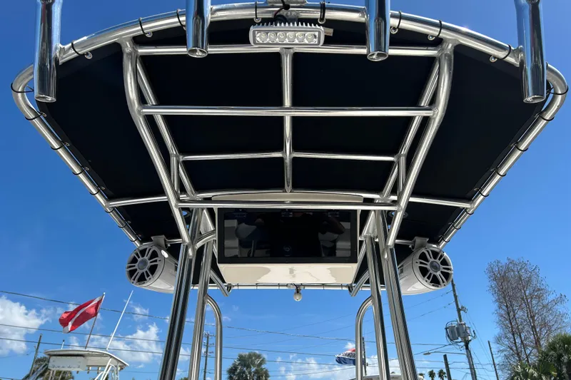 Slide: The Image of 2021 Bulls Bay 2200 boat T-top with speakers and blue sky background. - 13