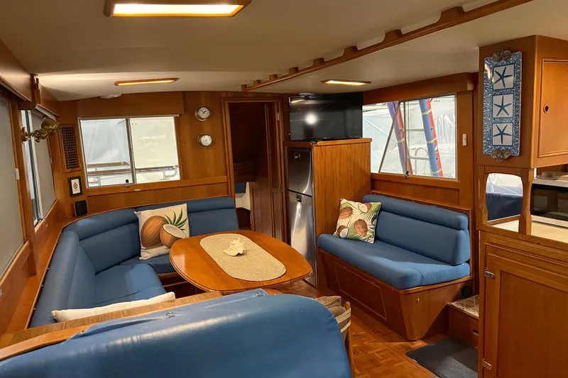 Slide: The Image of Interior of 1991 Grand Banks 42 Classic yacht with blue seating and wooden accents. - 11