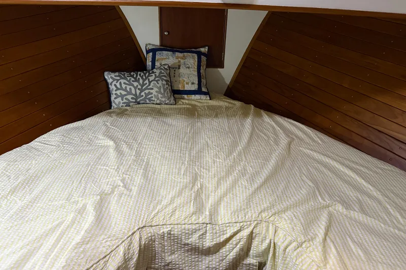 Slide: The Image of Cozy cabin bed in 1991 Grand Banks 42 Classic yacht with wooden paneling and decorative pillows. - 68