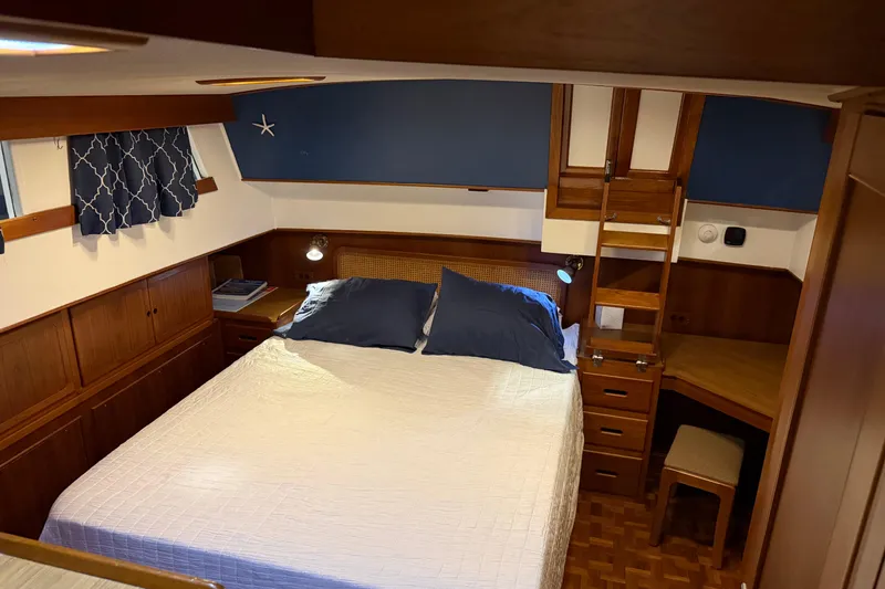Slide: The Image of Cozy bedroom in 1991 Grand Banks 42 Classic yacht with wood accents and blue decor. - 50