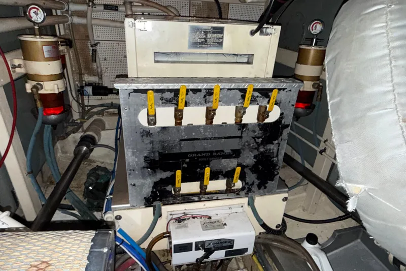 Slide: The Image of Engine room of a 1991 Grand Banks 42 Classic yacht, showing mechanical components and gauges. - 115