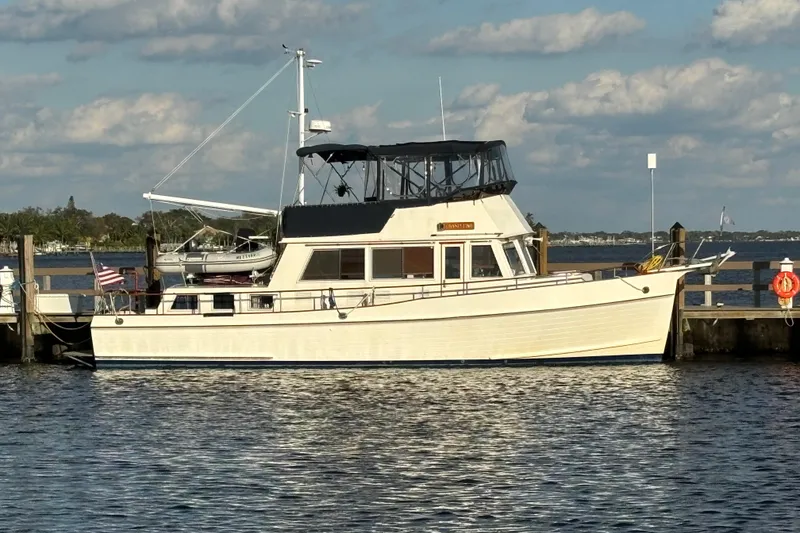 The Image of 1991 Grand Banks 42 Classic yacht docked at a marina under a partly cloudy sky. - 1