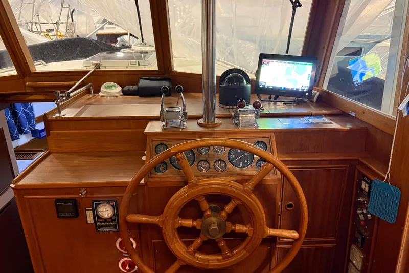 Slide: The Image of 1991 Grand Banks 42 Classic helm with wooden wheel and navigation instruments. - 34