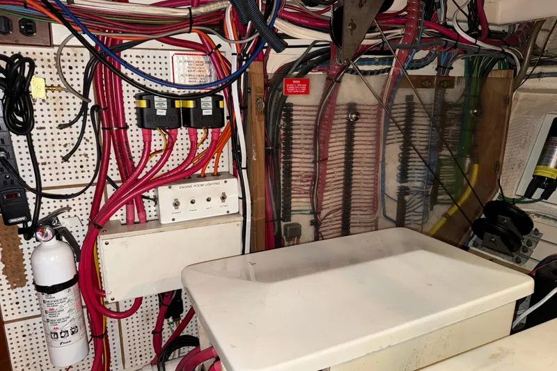 Slide: The Image of Engine room wiring of 1991 Grand Banks 42 Classic boat, featuring cables and fire extinguisher. - 118