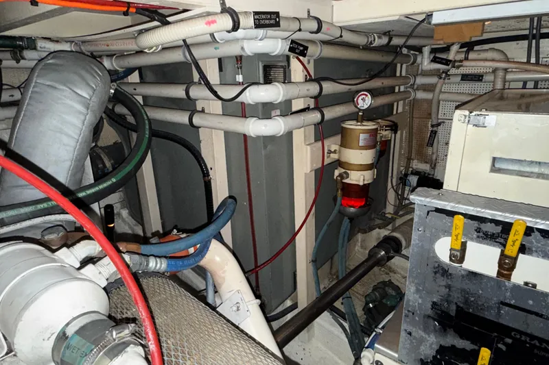 Slide: The Image of Engine room of a 1991 Grand Banks 42 Classic yacht, showcasing pipes and machinery. - 114