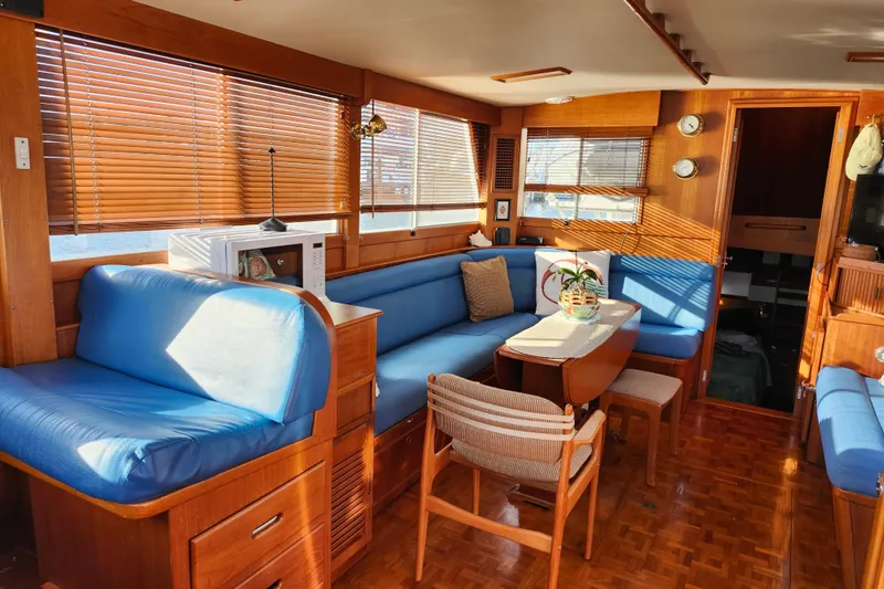 Slide: The Image of Interior of a 1991 Grand Banks 42 Classic yacht with blue seating and wooden accents. - 16