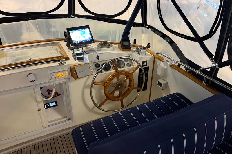 Slide: The Image of Helm of 1991 Grand Banks 42 Classic yacht with wooden wheel and navigation equipment. - 84