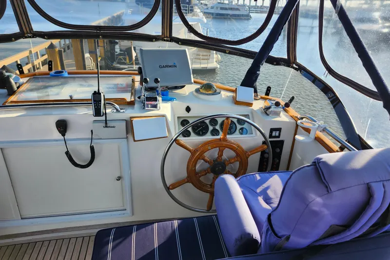 Slide: The Image of Helm of 1991 Grand Banks 42 Classic yacht with navigation equipment and wooden steering wheel. - 83