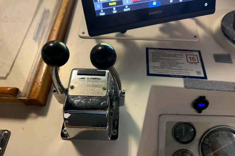 Slide: The Image of 1991 Grand Banks 42 Classic marine engine control panel with Morse levers and Garmin display. - 95