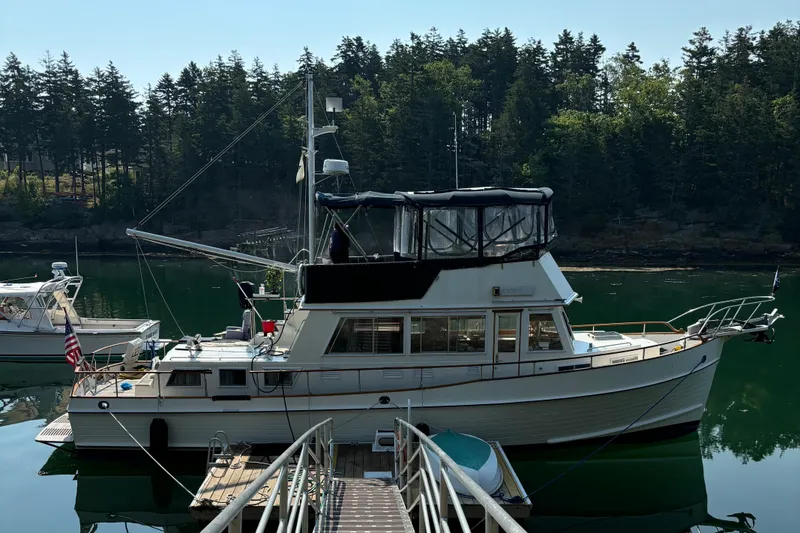Slide: The Image of 1991 Grand Banks 42 Classic yacht docked in a serene forested marina. - 8