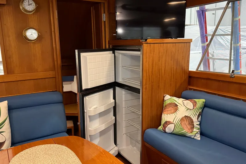 Slide: The Image of Interior of 1991 Grand Banks 42 Classic yacht with open fridge and cozy seating area. - 24