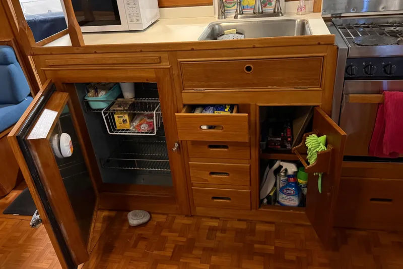 Slide: The Image of 1991 Grand Banks 42 Classic kitchen with wooden cabinets, open fridge, and sink area. - 30