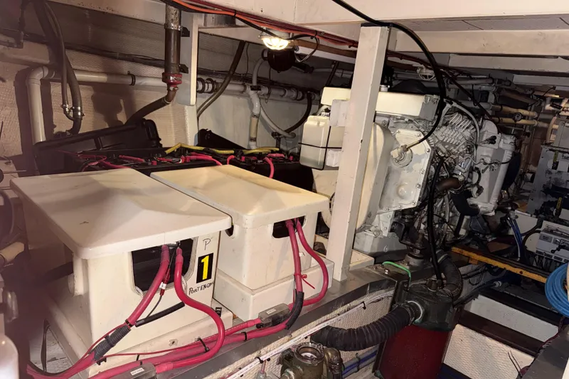 Slide: The Image of Engine room of a 1991 Grand Banks 42 Classic yacht, featuring batteries and machinery. - 104