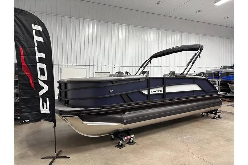 The Image of 2026 Evotti 521CS pontoon boat displayed indoors with branded flag. - 1