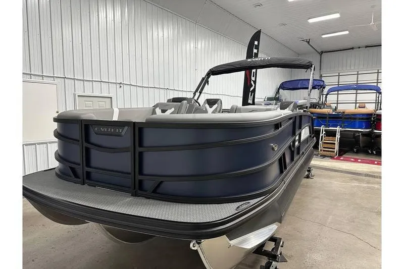 Slide: The Image of 2026 Evotti 521CS pontoon boat in showroom, featuring sleek design and modern seating. - 9