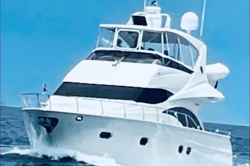 Slide: The Image of 2005 Marquis Pilothouse yacht cruising on open water under clear blue skies. - 22