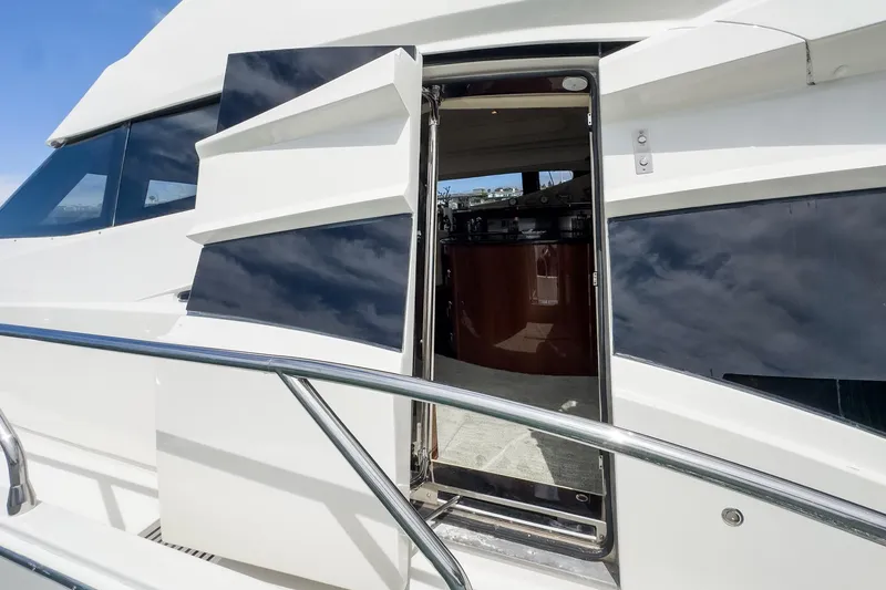 Slide: The Image of 2005 Marquis Pilothouse yacht exterior with open door and sleek design. - 27