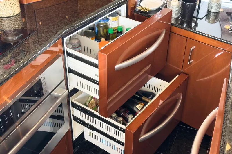 Slide: The Image of Luxury yacht kitchen with open wooden drawers, showcasing organized storage in a 2005 Marquis Pilothouse. - 36