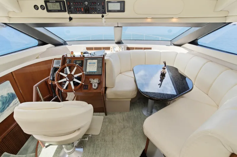 Slide: The Image of Luxurious 2005 Marquis Pilothouse yacht interior with helm, plush seating, and elegant table. - 38