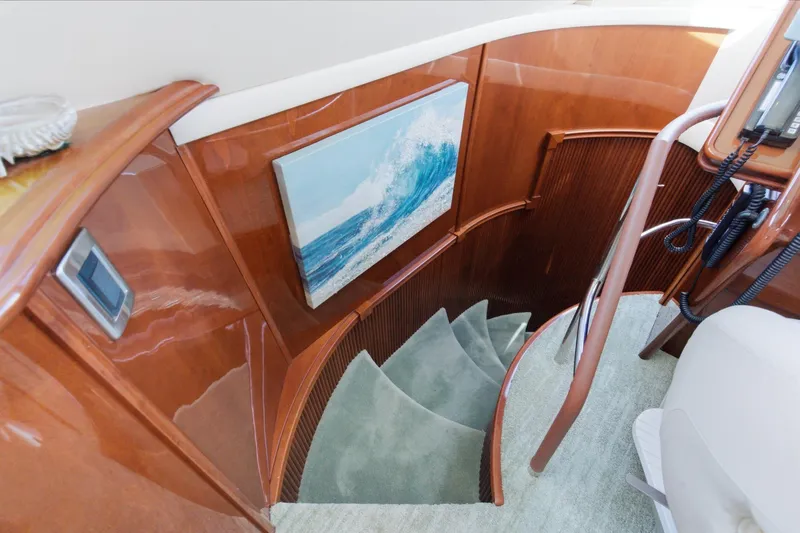 Slide: The Image of Interior of 2005 Marquis Pilothouse yacht with elegant wooden staircase and ocean artwork. - 45