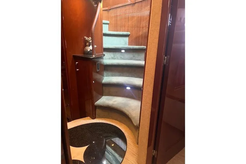 Slide: The Image of Luxurious 2005 Marquis Pilothouse yacht interior with elegant curved staircase and ambient lighting. - 5