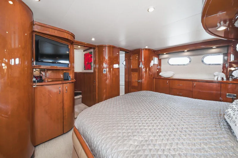 Slide: The Image of Luxurious 2005 Marquis Pilothouse yacht bedroom with wood paneling and modern amenities. - 50