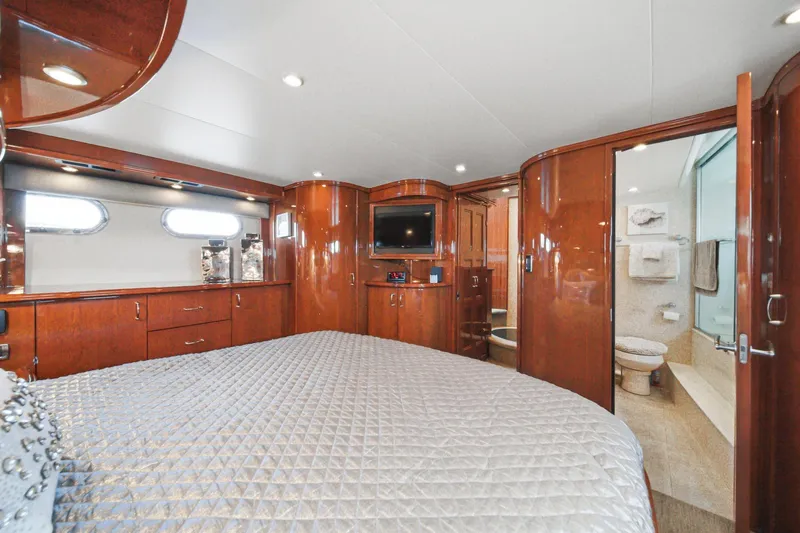 Slide: The Image of Luxurious 2005 Marquis Pilothouse yacht bedroom with elegant wood finishes and ensuite bathroom. - 51