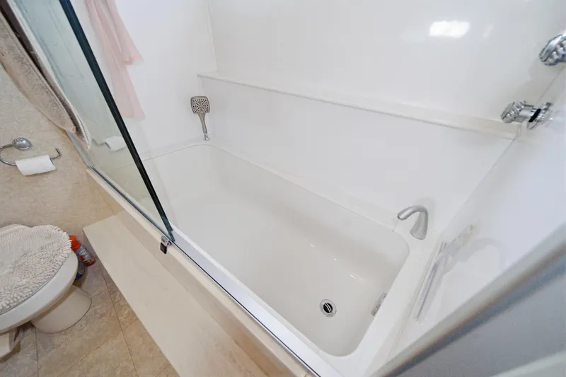 Slide: The Image of Modern bathroom with a white bathtub and glass shower door in a 2005 Marquis Pilothouse. - 54