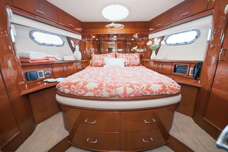 Slide: The Image of Luxurious 2005 Marquis Pilothouse yacht bedroom with elegant wood finish and floral bedding. - 57