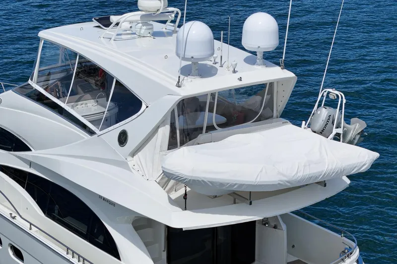 Slide: The Image of 2005 Marquis Pilothouse yacht with covered deck, radar domes, and ocean backdrop. - 61