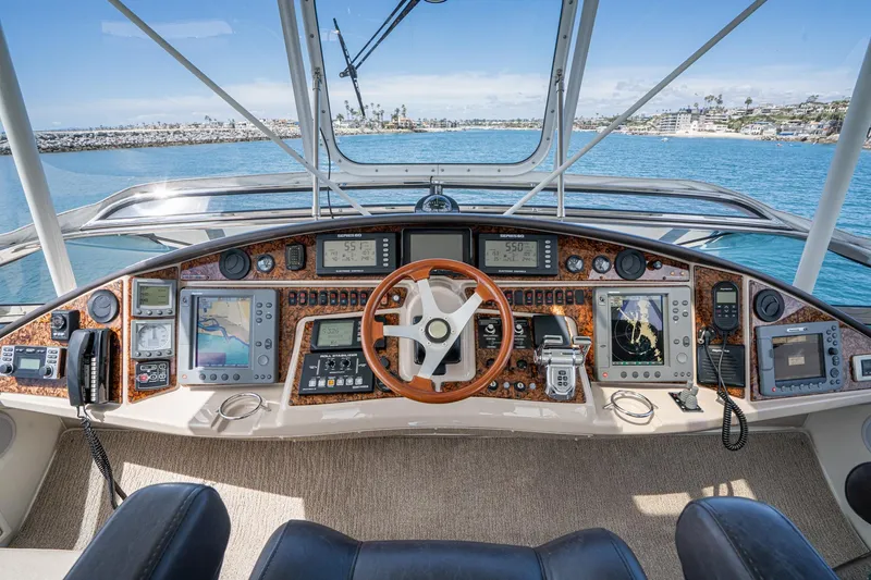 Slide: The Image of Pilothouse interior of a 2005 Marquis yacht with advanced navigation equipment and wooden steering wheel. - 65