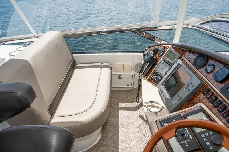 Slide: The Image of Pilothouse interior of 2005 Marquis yacht with navigation instruments and seating, overlooking the ocean. - 66
