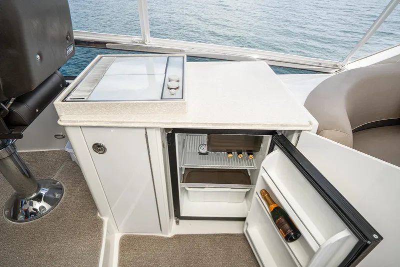 Slide: The Image of 2005 Marquis Pilothouse yacht interior with mini fridge and countertop, overlooking the ocean. - 67