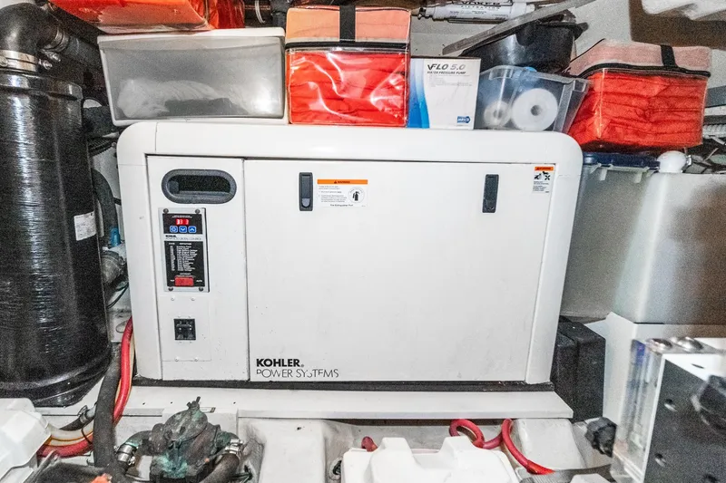 Slide: The Image of Kohler power system in 2005 Marquis Pilothouse engine room, surrounded by storage containers. - 74