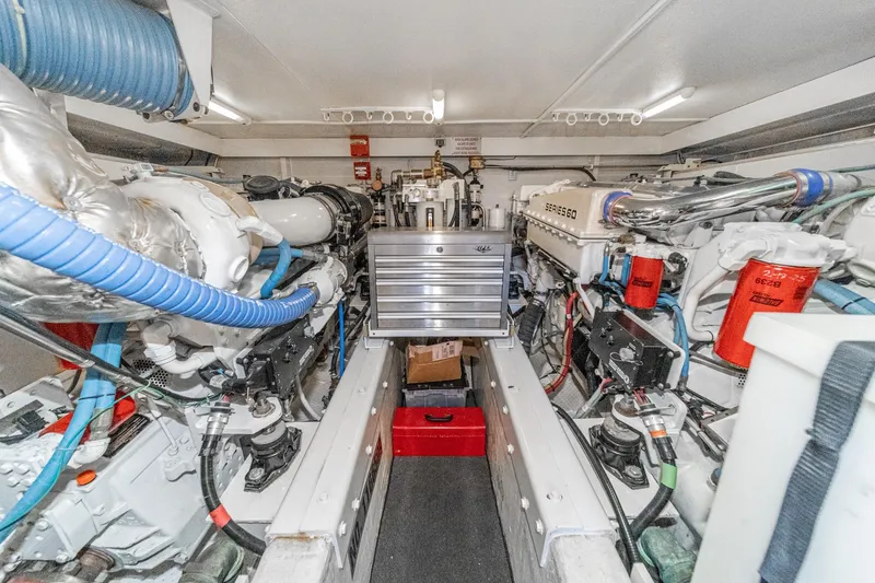 Slide: The Image of Engine room of a 2005 Marquis Pilothouse yacht, featuring dual engines and organized equipment. - 76