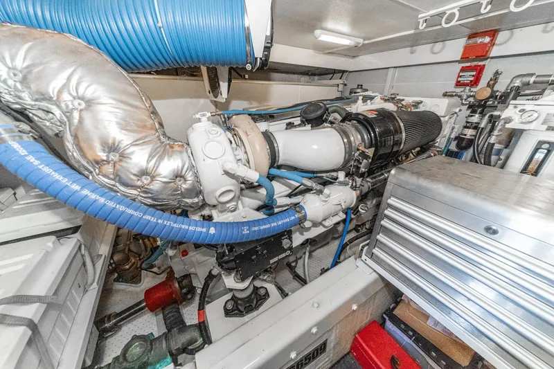 Slide: The Image of Engine room of a 2005 Marquis Pilothouse yacht, featuring complex machinery and piping. - 78