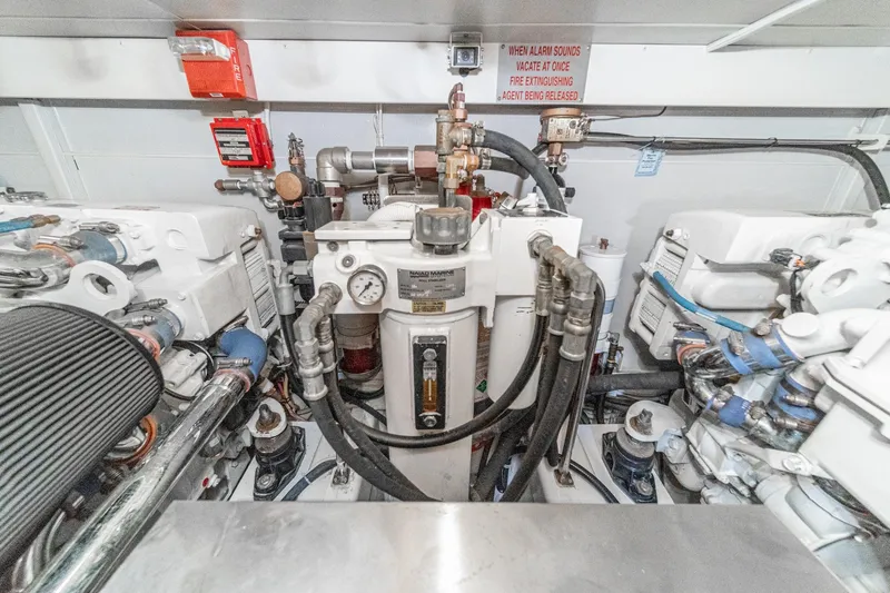 Slide: The Image of Engine room of a 2005 Marquis Pilothouse yacht, featuring machinery and safety equipment. - 79