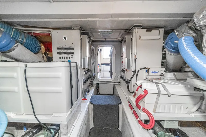 Slide: The Image of Engine room of a 2005 Marquis Pilothouse yacht, featuring equipment and control panels. - 80