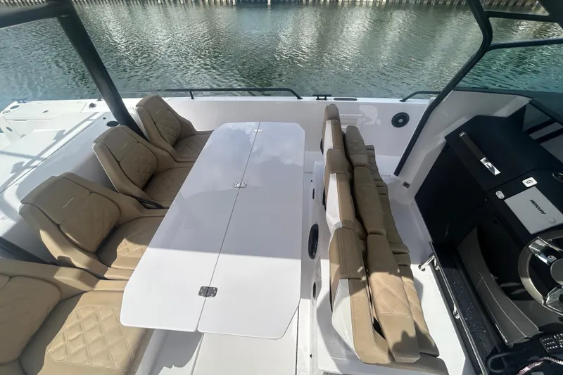 Slide: The Image of 2021 Axopar 37 Sun-Top boat interior with beige seating and white table. - 11