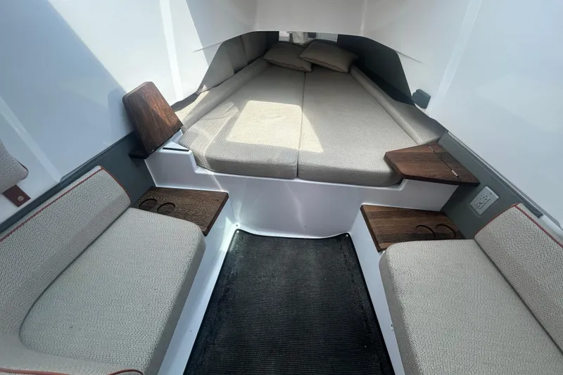 Slide: The Image of 2021 Axopar 37 Sun-Top cabin interior with cushioned seating and wooden accents. - 17