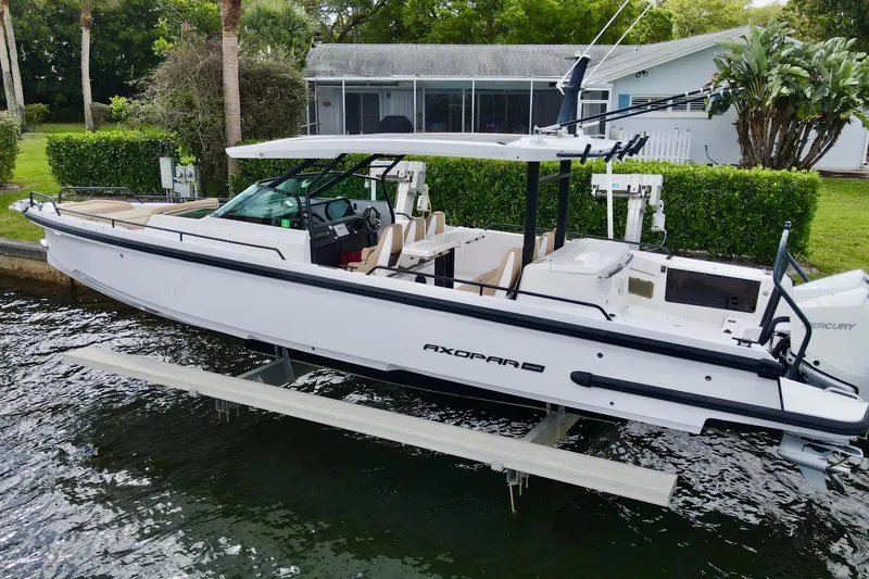 Slide: The Image of 2021 Axopar 37 Sun-Top boat docked by a waterfront home. - 2