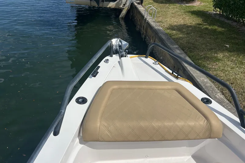 Slide: The Image of Bow view of 2021 Axopar 37 Sun-Top with tan seating, docked by water. - 20