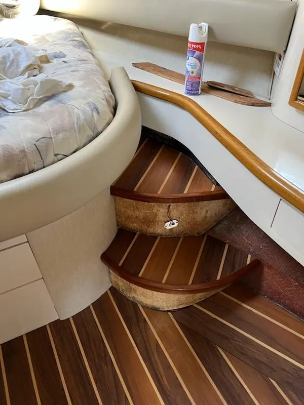 Slide: The Image of Interior of 1995 Sea Ray 450 Sundancer with wooden steps and cozy cabin decor. - 15