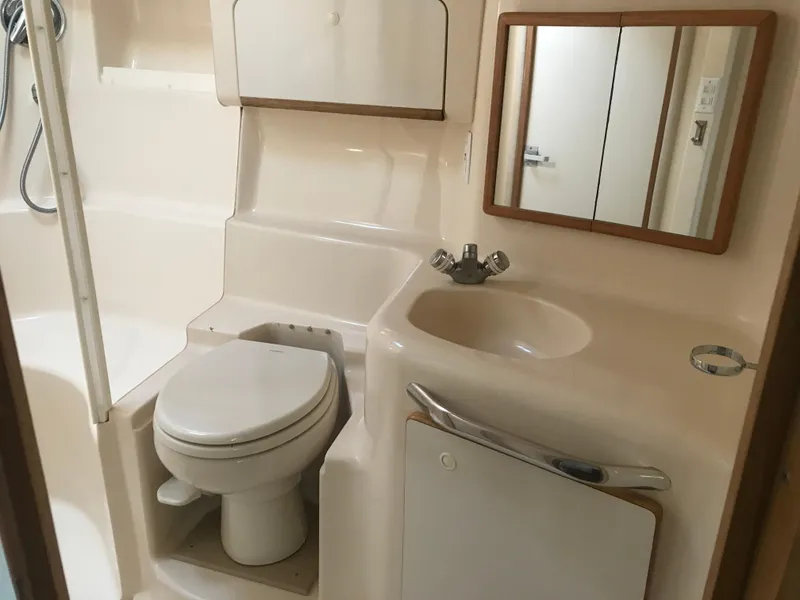 Slide: The Image of 1995 Sea Ray 450 Sundancer bathroom with toilet, sink, and mirror. - 25