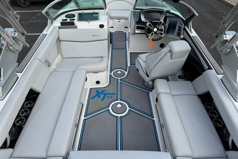 Slide: The Image of 2021 MasterCraft XT22 boat interior with sleek seating and modern dashboard design. - 19