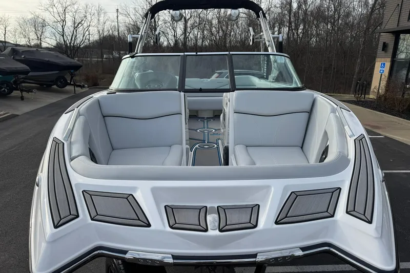 Slide: The Image of 2021 MasterCraft XT22 boat with sleek white interior and modern design, parked outdoors. - 8