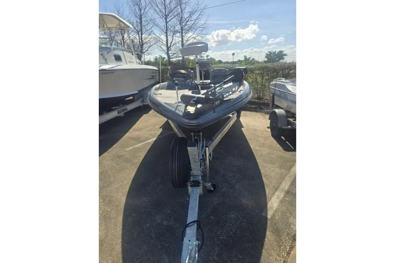 Slide: The Image of 2006 Triton Tr-176 boat on trailer, parked outdoors under clear sky. - 2