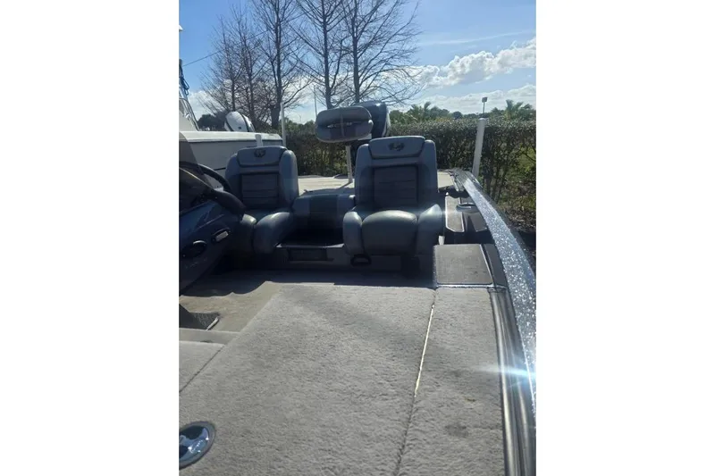 Slide: The Image of 2006 Triton Tr-176 boat interior with dual seats and steering wheel, under clear sky. - 6